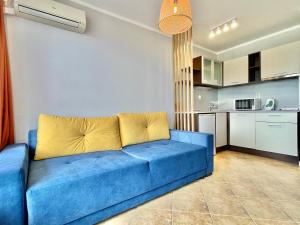 a blue couch in a living room with a kitchen at Arkite - Private apartment - BSR in Sunny Beach
