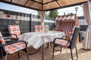 Sundhagen-NiederhofにあるBungalow Bei Rügenのパティオ(パラソルの下にテーブルと椅子付)