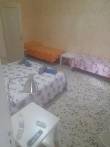 a room with two beds and a table at Bed and fly Aeroporto Fontanarossa reception h24 in Catania