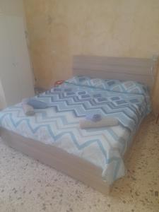 a bed with a blue and white comforter in a room at Bed and fly Aeroporto Fontanarossa reception h24 in Catania