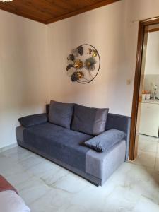 a couch in a living room with a clock on the wall at Veny House in Paralia Panteleimonos