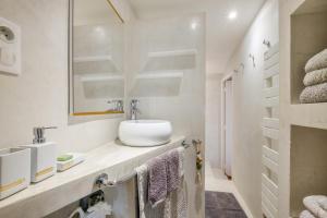 a white bathroom with a sink and a mirror at Maison de village romantique in Cagnes-sur-Mer