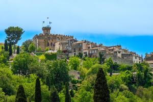 a town on a hill with trees and buildings at Maison de village romantique in Cagnes-sur-Mer