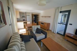 a living room with a couch and a dining room at Apartamentos Turísticos Vicotel in Teruel