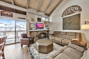een woonkamer met een bank en een open haard bij Lakeland Village 481 - Family Footprints by the Lake-Sleeps 10 in South Lake Tahoe