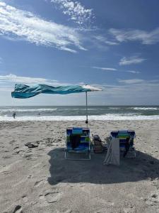 dos sillas y una sombrilla en una playa en Lil'TipSea on Topsail - Close to the sound and beach! en Topsail Beach
