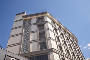 イスタンブールにあるKing City Hotelの白い高い建物(窓付)
