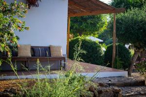 una panca di legno seduta sotto un padiglione in un giardino di Quinta Alcarias a Santa Catarina da Fonte do Bispo