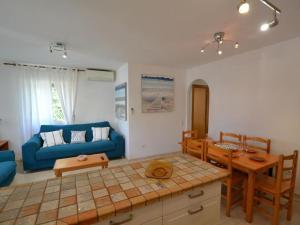 a living room with a blue couch and a table at Viamar in Riumar +26 photos
