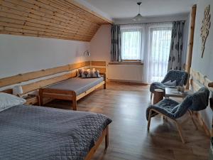 1 Schlafzimmer mit 2 Betten, einem Tisch und Stühlen in der Unterkunft Przy Szlaku Zakopane centrum pokoje & apartamenty in Zakopane