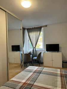Un dormitorio con una cama y un escritorio y una ventana. en No 13 House Raca, en Bratislava