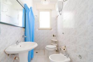 a white bathroom with a sink and a toilet at Villa Ottavia in Torre Lapillo +19 photos