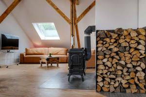 a living room with a fireplace and a pile of wood at Roger`s Ferienwohnung in Dießen am Ammersee