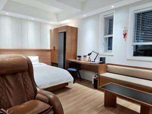 1 dormitorio con cama, escritorio y piano en Gran Hotel en Gunsan