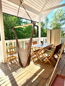 a hammock on a porch with a table and chairs at Villa Tilda in Mathildedal +29 photos