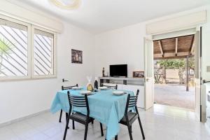 a dining room with a blue table and chairs at Villa Ottavia in Torre Lapillo