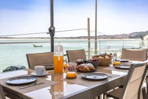 a table with food and a view of the water at Paradise bay T3 in São Martinho do Porto