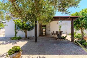 a patio with trees in front of a building at Villa Ottavia in Torre Lapillo