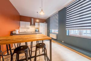 a kitchen with a wooden counter and stools in it at Smartflats City - Brusselian in Brussels