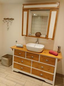 a bathroom with a sink and a mirror on a dresser at Chambre d'hôtes La Tuilerie in Saint-Menoux +13 photos