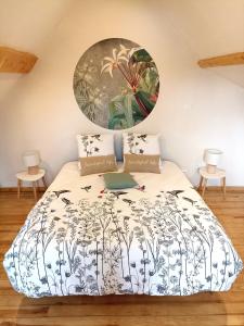 a bedroom with a bed with a painting on the wall at Chambre d'hôtes La Tuilerie in Saint-Menoux