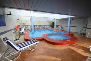 a large swimming pool in a building with a chair at City Tower Hotel in Fujairah