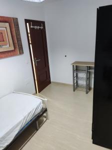 - une chambre avec un lit, une porte et une table dans l'établissement Piso Bajo Santa Ana, à Roquetas de Mar
