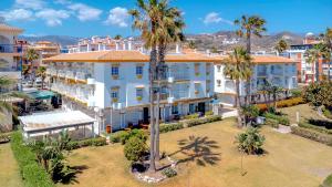 an aerial view of a large white building with palm trees at Seaflower Torrox Costa in Torrox Costa