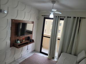 ウバトゥバにあるApartamento à 5min à pé da Praiaのリビングルーム(テレビ、窓付)