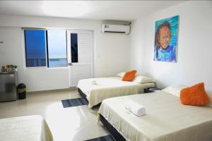 a room with two beds and a painting on the wall at Hotel Molino de Viento in San Andrés