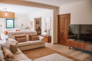 a living room with a couch and a flat screen tv at Just Like Home - Casa de São Sebastião em Cerveira in Linhares +37 photos