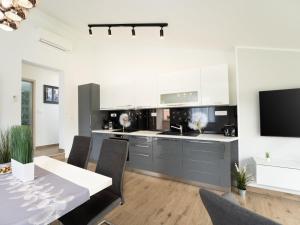 een keuken met witte kasten en een tafel met stoelen bij Apartment Gaia in Labin