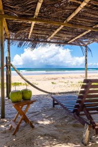a hammock and a chair on a beach at Apartamento pé na areia em Algodões, Península de Maraú Bahia in Marau