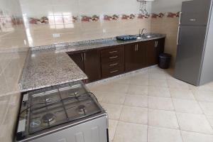 a kitchen with a stove and a refrigerator at Logement familial 3 in Selouane