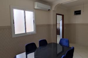 a meeting room with a table and blue chairs at Logement familial 3 in Selouane