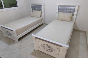 two twin beds in a room at Logement familial 3 in Selouane +6 photos