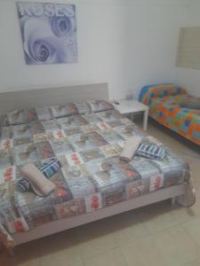 a bedroom with a bed with a comforter at Bed and fly Aeroporto Fontanarossa reception h24 in Catania