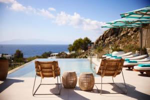 a pool at a resort with chairs and the ocean at Nammos Hotel Mykonos in Psarou