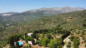 an aerial view of a mountain with a house and a pool at Finca Rural La Calderera in Valdepeñas de Jaén
