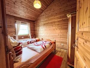 a bedroom with two beds in a log cabin at Holiday Home Schöne Aussicht by Interhome in Müllenbach