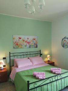 ein Schlafzimmer mit einem Bett mit zwei rosa Kissen in der Unterkunft B&B Stella dell'Adriatico in Ortona