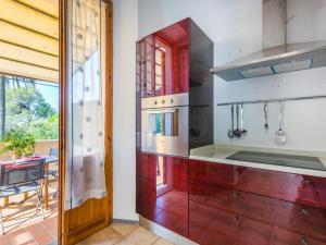 una cocina con estufa horno superior al lado de una ventana en Apartment Beach home by Interhome, en Castiglioncello