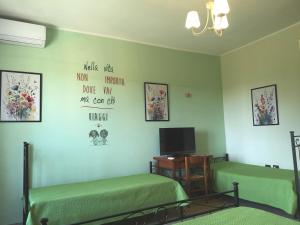 a bedroom with two beds and a tv on the wall at B&B Stella dell'Adriatico in Ortona