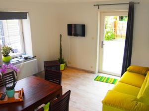 ein Wohnzimmer mit einem gelben Sofa und einem Tisch in der Unterkunft Holiday Home Gîte L'Archipel by Interhome in Ellezelles