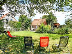 three chairs sitting in the grass in a yard at Holiday Home Gîte L'Archipel by Interhome in Ellezelles