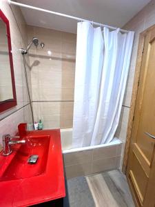 カルボネラスにあるÁtico con vistas al marのバスルーム(赤いシンク、バスタブ付)