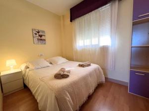 カルボネラスにあるÁtico con vistas al marのベッドとタオル2枚のある寝室