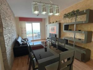 カルボネラスにあるÁtico con vistas al marのダイニングテーブルとソファのあるリビングルーム +3枚の写真