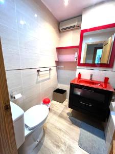 カルボネラスにあるÁtico con vistas al marのバスルーム(白いトイレ、赤いシンク付)