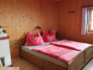 ein Schlafzimmer mit einem Bett mit roten Kissen darauf in der Unterkunft Chalet Kopphütte by Interhome in Preims